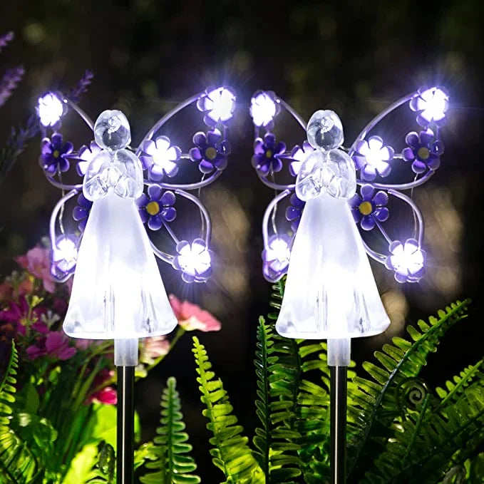 Set of two solar angel pathway lights illuminating a garden at dusk, ideal yard art and landscape decor.
