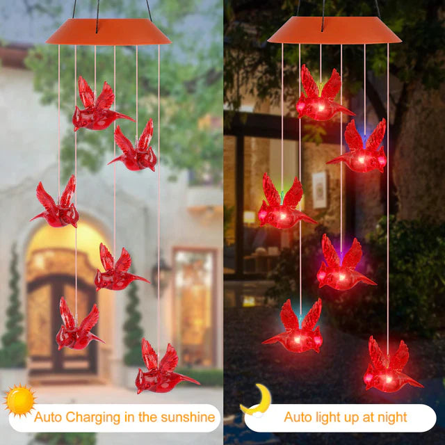 Decorative solar wind chime with vibrant cardinal figures and glowing LED outdoor light