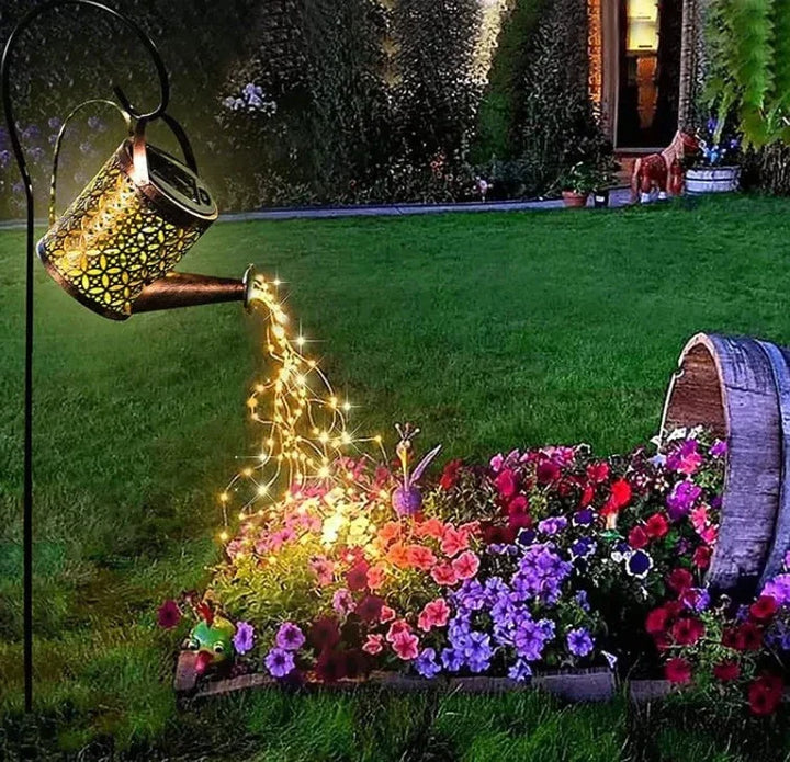 Solar glowing watering can with fairy lights, perfect garden decor for outdoor lighting.