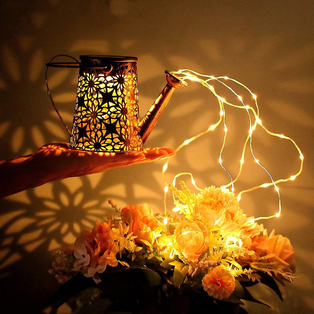 Elegant metal solar watering can with cascading fairy lights, enhances outdoor living areas.