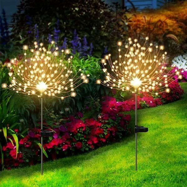 Solar powered firework garden lights illuminating a dark garden, creating a festive outdoor ambiance.