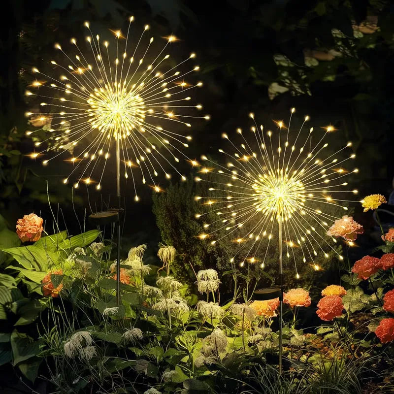 Multiple solar firework lights arranged in a flower bed, enhancing garden beauty with fairy lights.