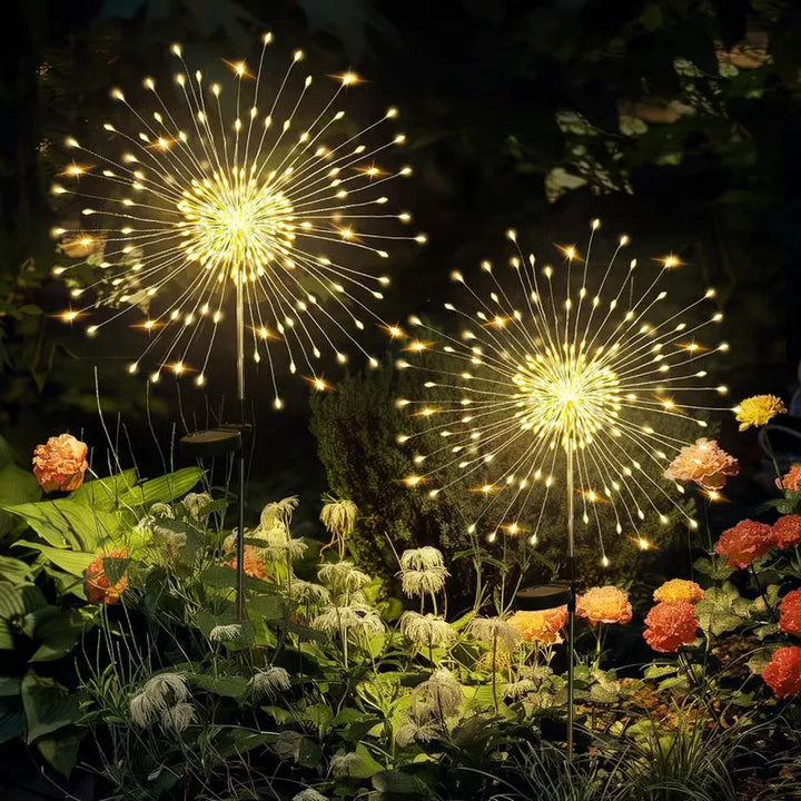 Multiple solar firework lights arranged in a flower bed, enhancing garden beauty with fairy lights.