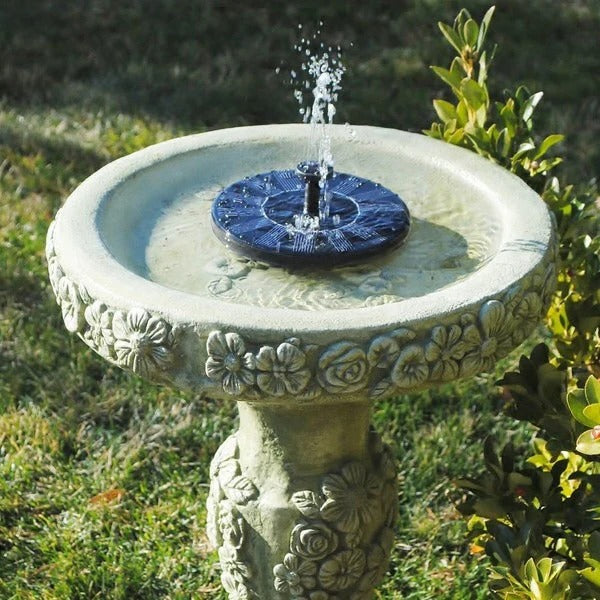 Solar powered floating water fountain pump in a pond, perfect for garden decor & bird baths.