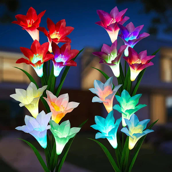 Solar powered LED lily flower garden stake light blooming at dusk, illuminating a garden path.