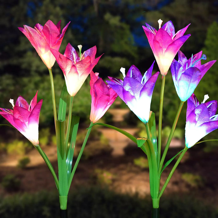 A set of multicolored solar LED lily flower lights enhancing outdoor garden decor at night.