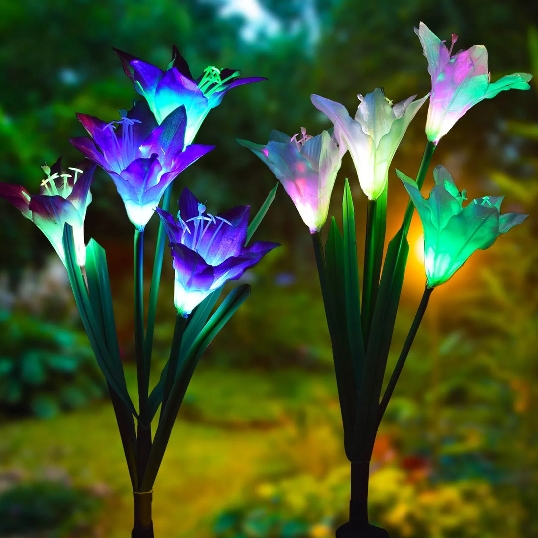 Solar LED lily flower lights adding elegant outdoor lighting to a garden landscape.