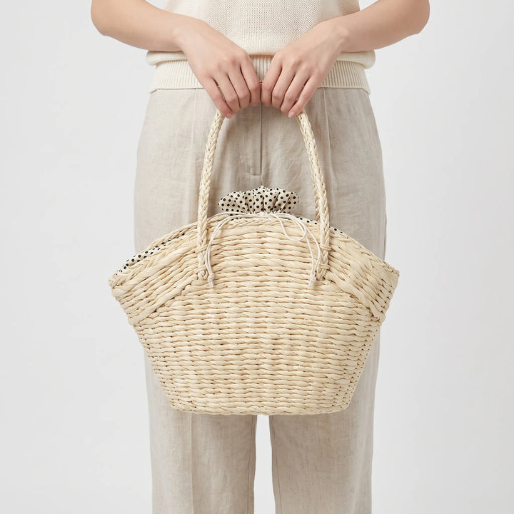 Close-up of a stylish women's woven summer tote bag, showcasing texture. Ideal large beach bag or daily casual carry.