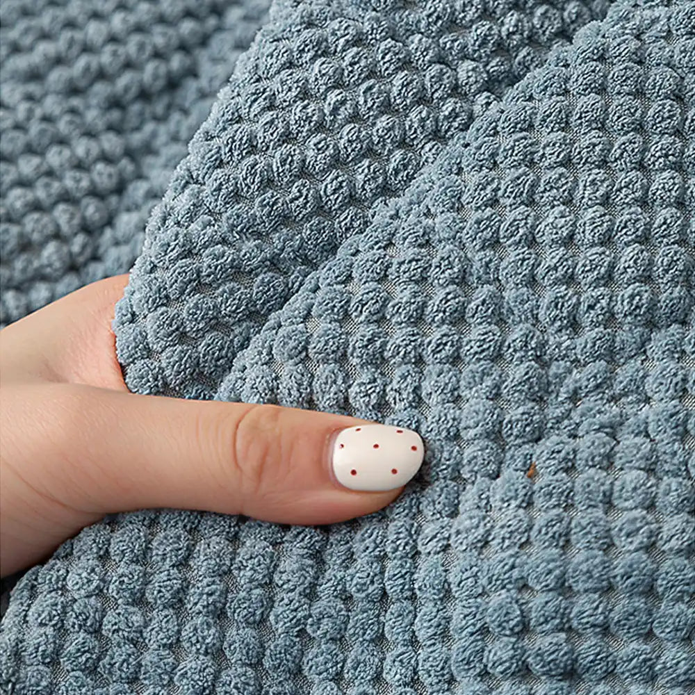 Detail of the non-slip backing on a square corduroy pet-friendly furniture protector.