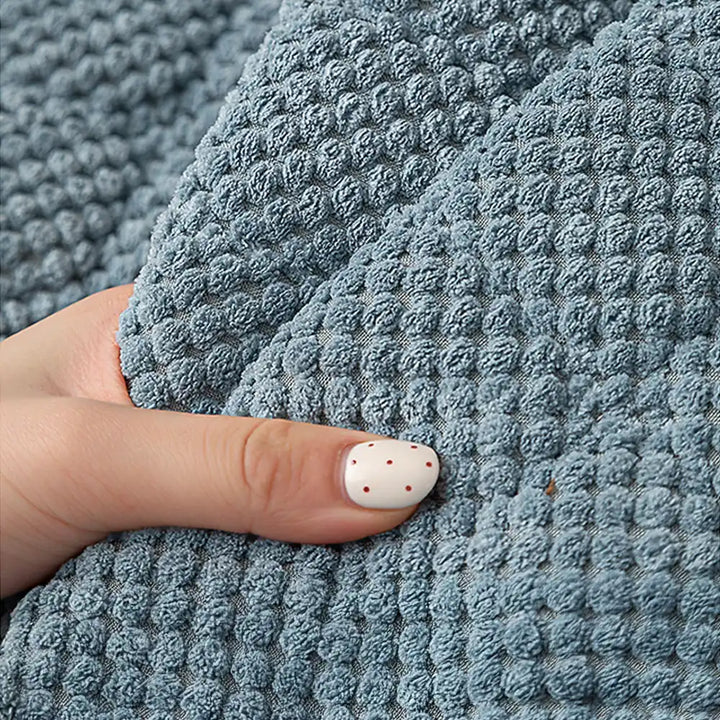 Detail of the non-slip backing on a square corduroy pet-friendly furniture protector.