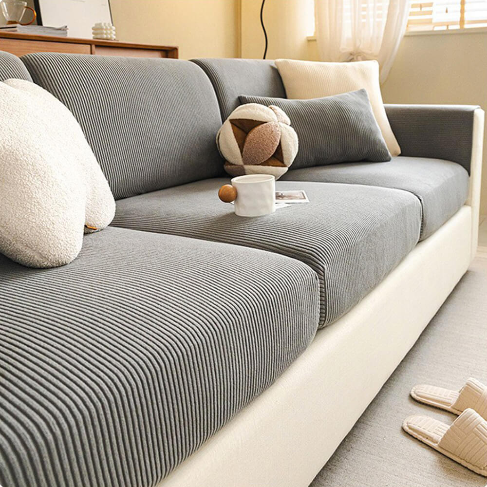 Lifestyle shot of stripe corduroy anti-scratch cover on a couch with cushions, living room decor