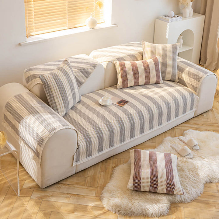 Full view of a living room sofa with striped cotton linen anti-scratch furniture protector cover.