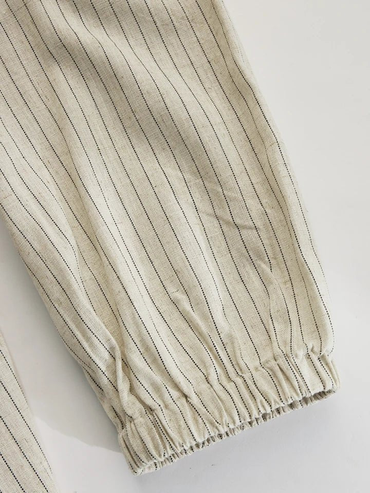 Full-length view of a women's striped V-neck maxi dress with puff sleeves and elegant side split.