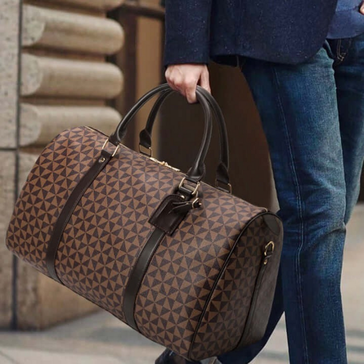 Sleek black unisex travel duffle bag, perfect carry-on luggage for business or casual weekend travel.