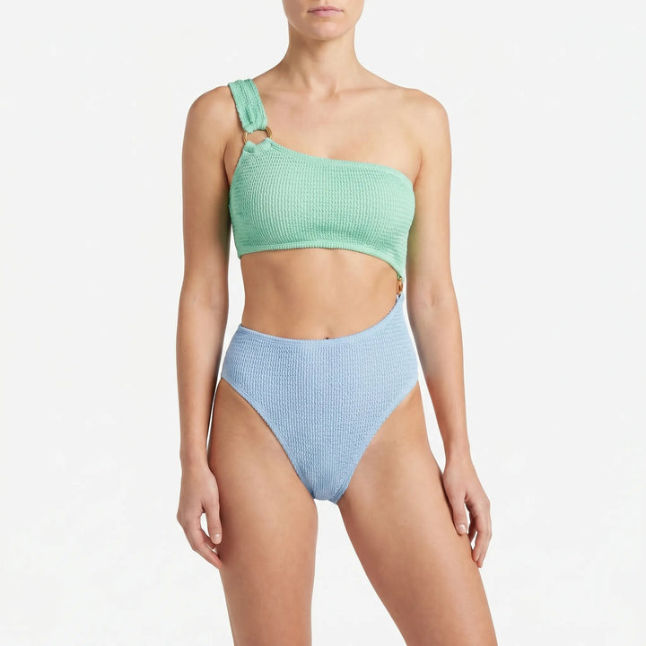 Trendy women's monokini with chic cut-outs & asymmetric design, featuring decorative gold rings for vacation essentials.
