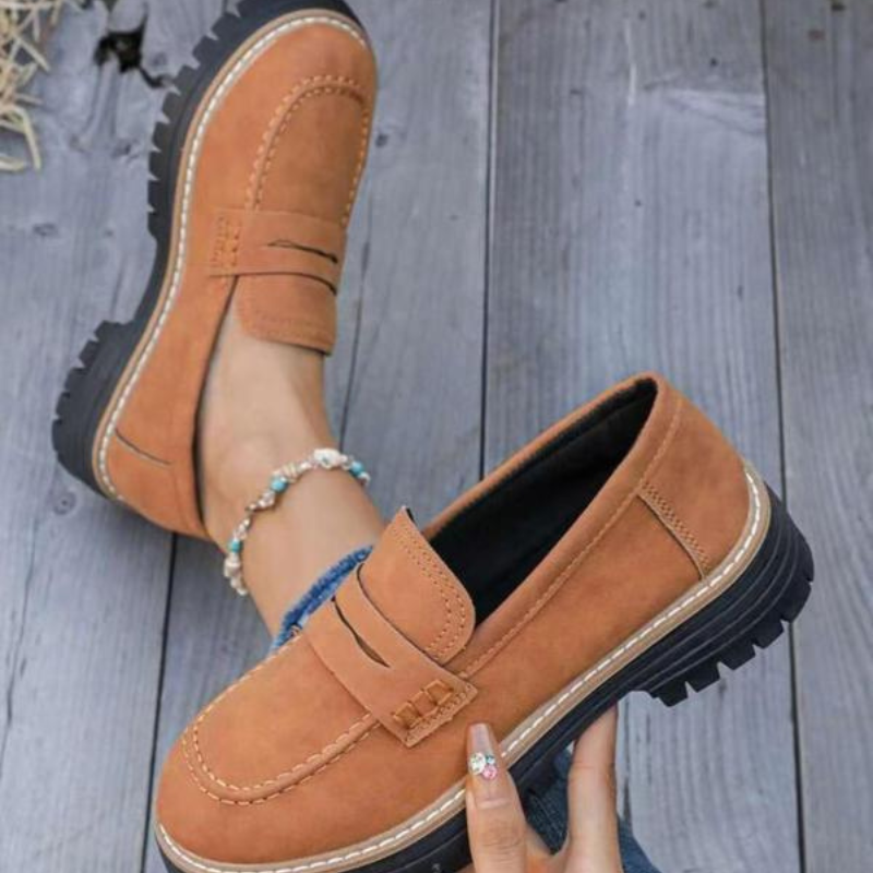 Fashionable brown women's slip-on loafers with a bold chunky platform, offering versatile style and comfort.