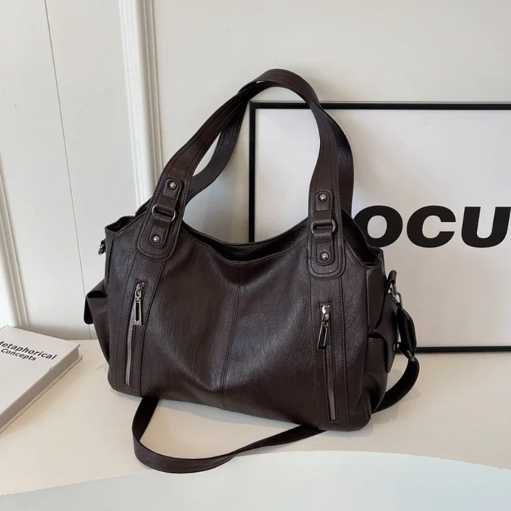 Fashionable maroon multi-compartment shoulder bag for women. A stylish everyday handbag, ideal for accessories.