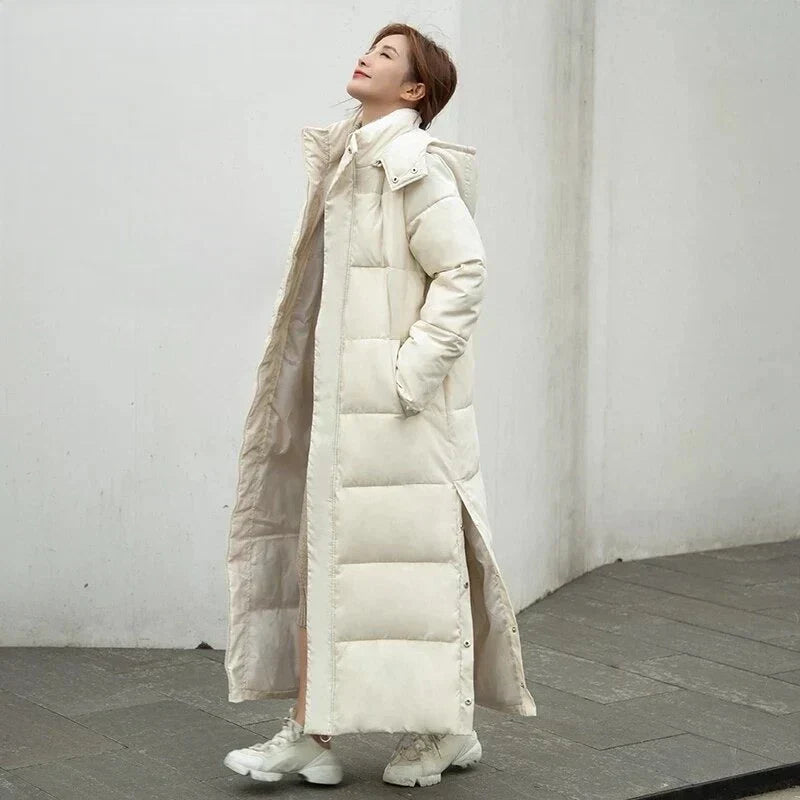 Women's warm quilted winter coat, long & hooded, ensuring cozy comfort and elegant style.