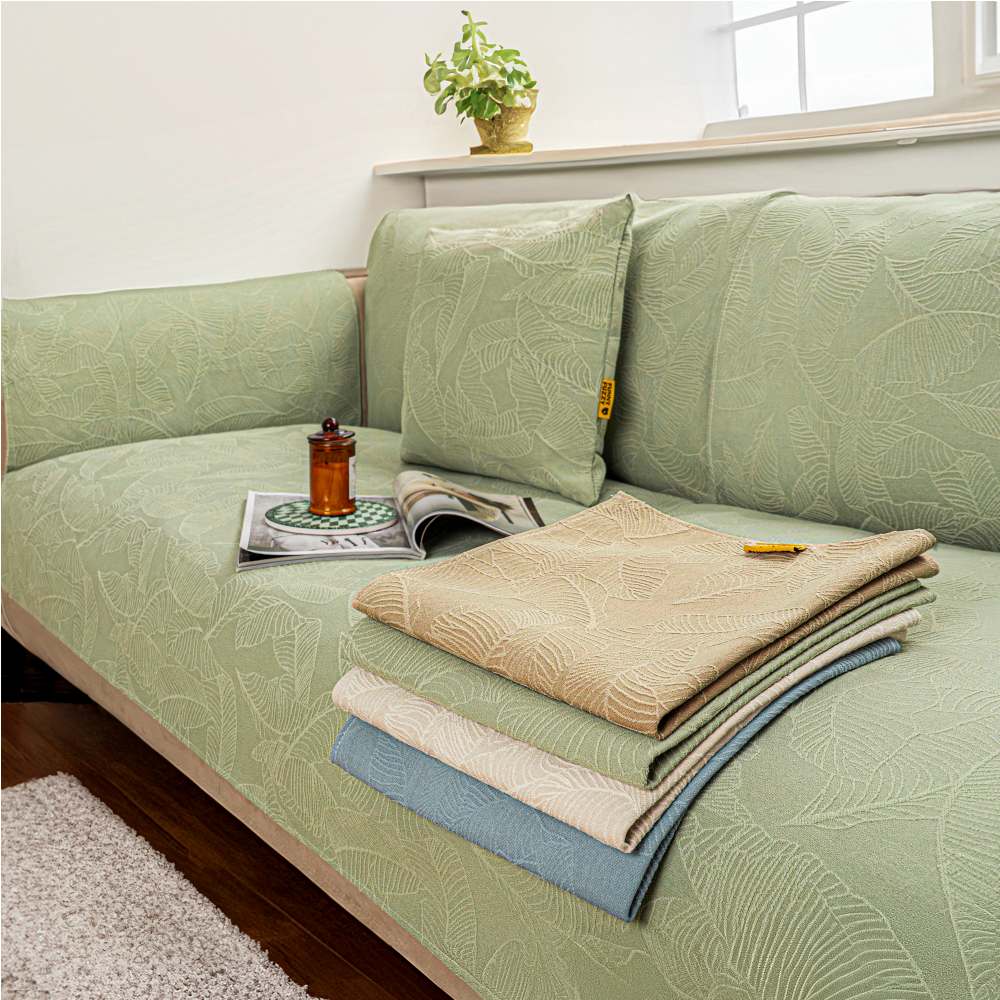 Textured jacquard sofa slipcover in neutral beige, protecting a living room couch.
