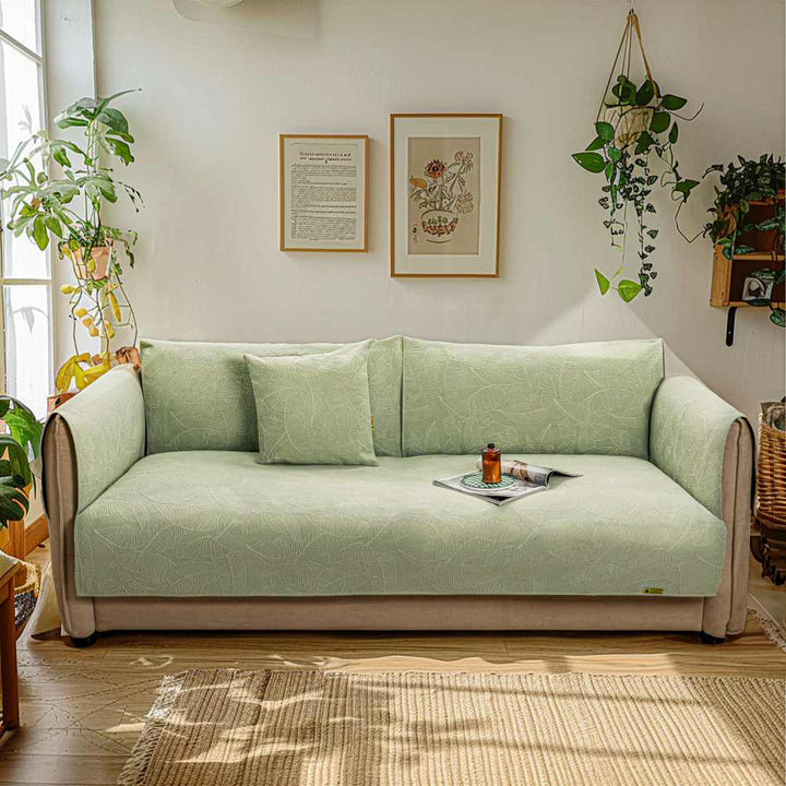 Stretch jacquard couch protector in a modern living room, fitting a three-seater sofa.