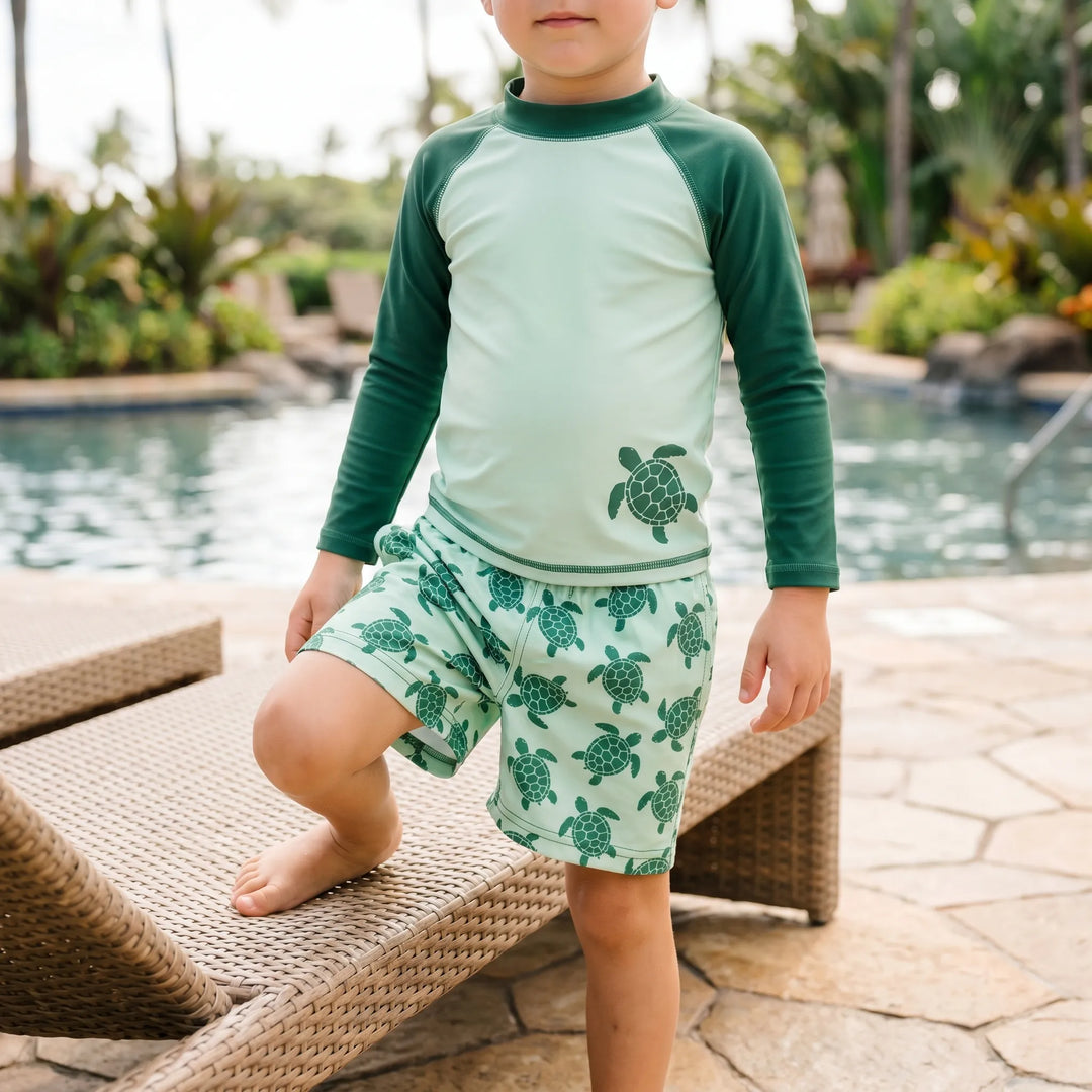 Toddler long-sleeve swimwear set with playful tortoise print. Rash guard & swim shorts for sun protection.