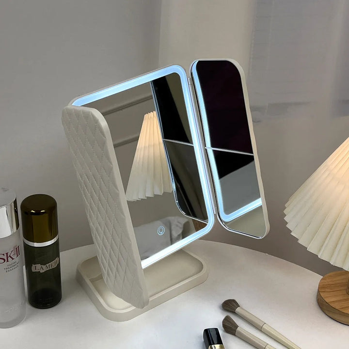 Compact trifold LED vanity mirror with adjustable light and magnification for precise cosmetic application & grooming.