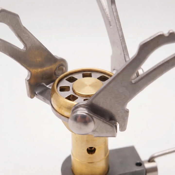 Portable hiking gas burner stove in use, showcasing its compact folding design for outdoor cooking.