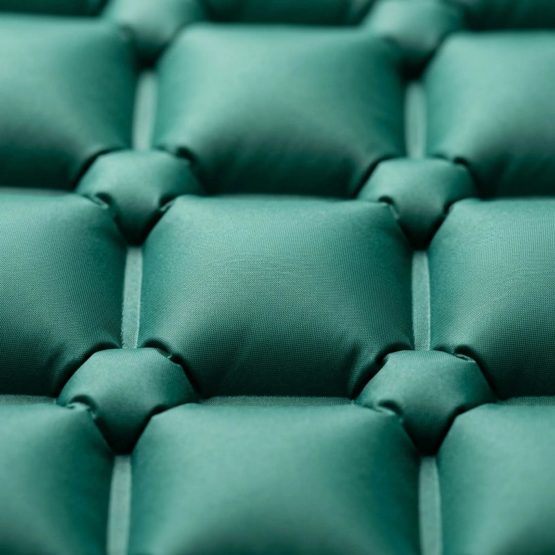 Comfortable inflatable sleeping mat with built-in pillow and pump, ideal for restful outdoor camping.