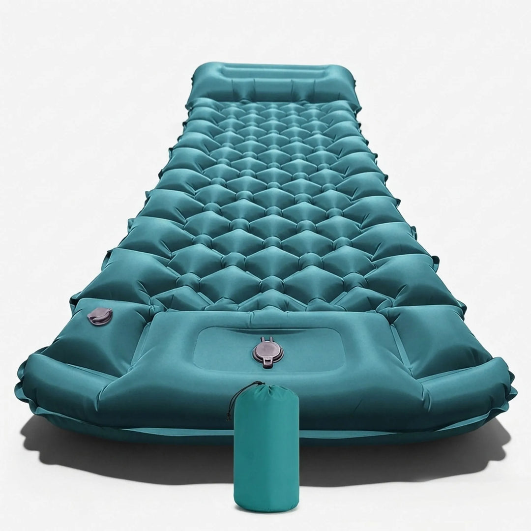 Hiker resting on an inflatable camping sleeping mat with built-in pillow & pump in a scenic outdoor setting.