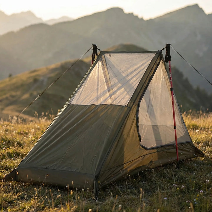 Ultralight single-person mesh tent set up with trekking poles, perfect for backpacking & hiking insect protection.