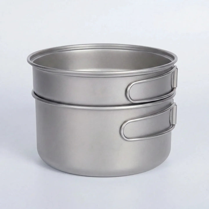 Complete ultralight titanium pot & pan set with folding handles, ideal for backpacking, camping, & hiking meals.