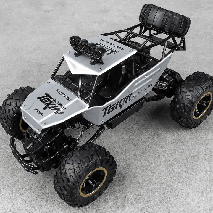 Unisex All-Terrain RC Monster Truck tackling a rocky path. Perfect off-road toy for kids & adults.