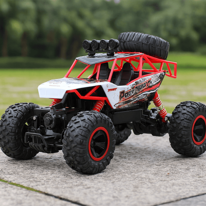 Detailed view of the ergonomic Remote Control unit next to the All-Terrain RC Truck.