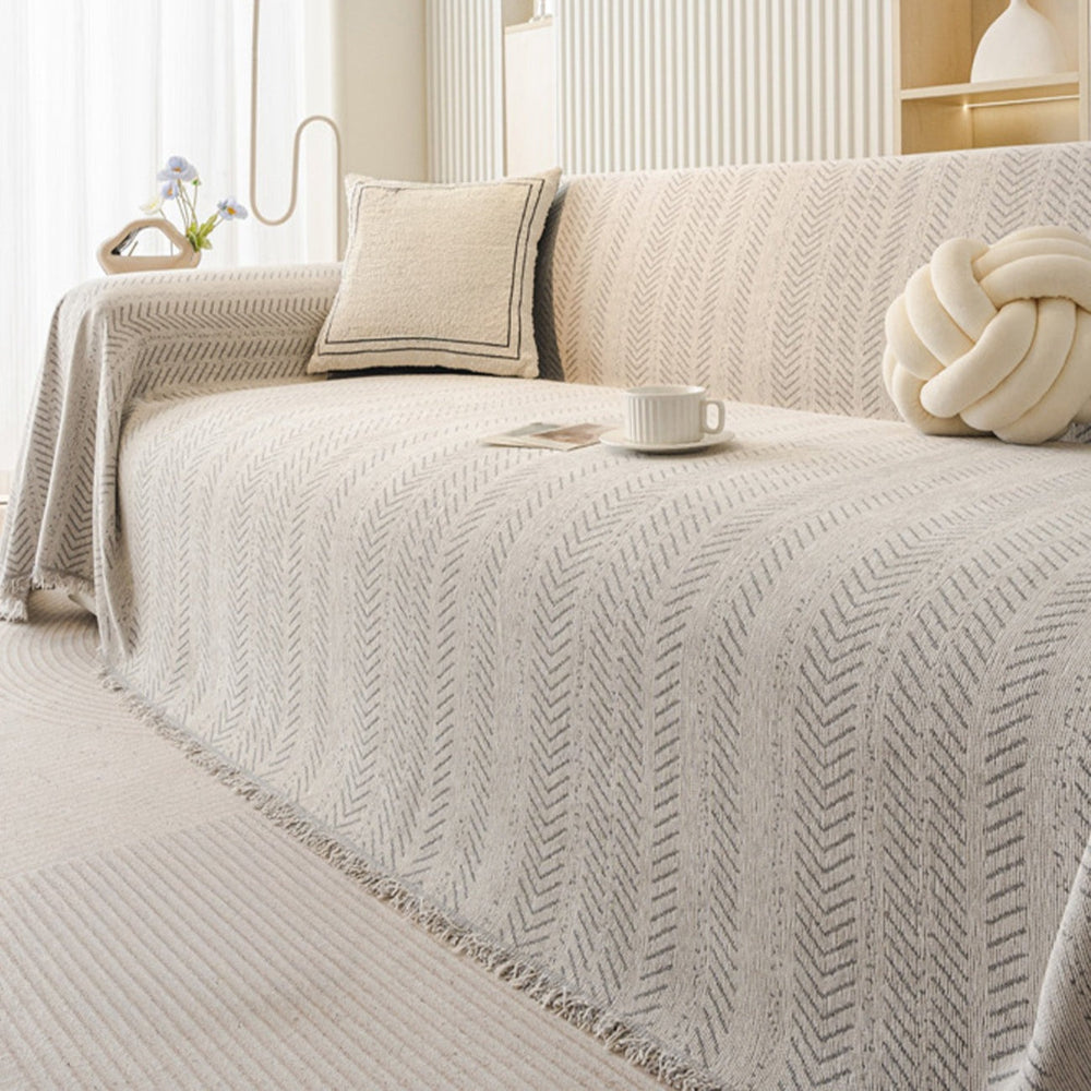 Beige chenille furniture protector draped over a sofa, showing its washable and durable design