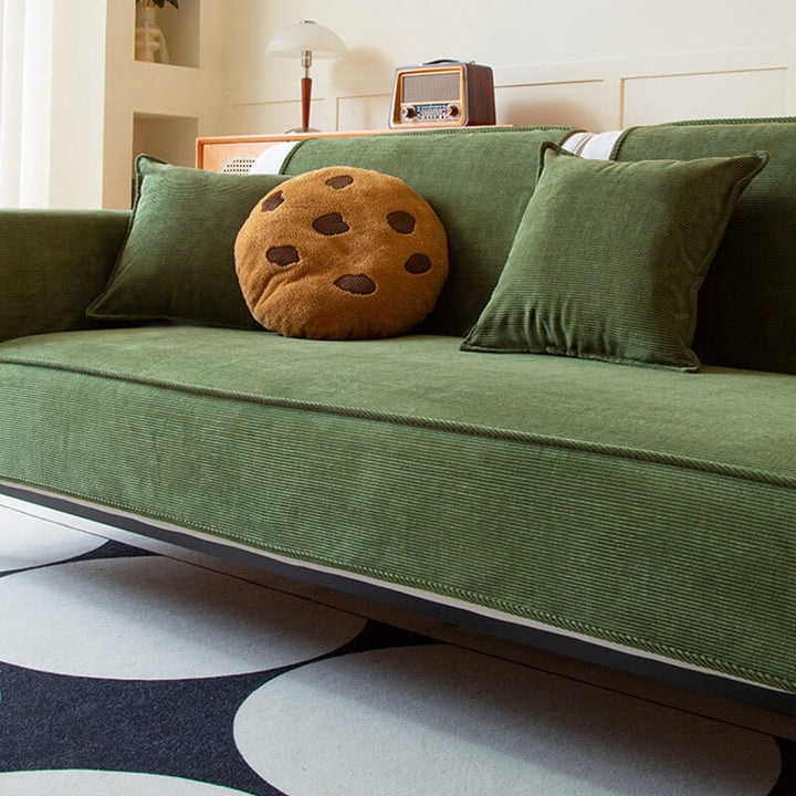 Pet-friendly anti-slip corduroy sofa cover, draped over a couch, offering stylish furniture protection.