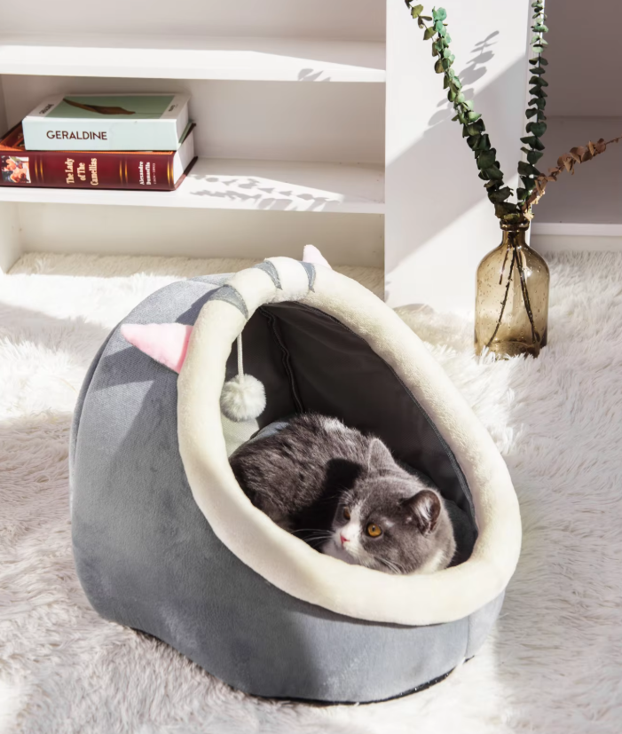Unisex cat igloo bed with a soft cushion and attached play ball, perfect for cozy sleep and comfort.