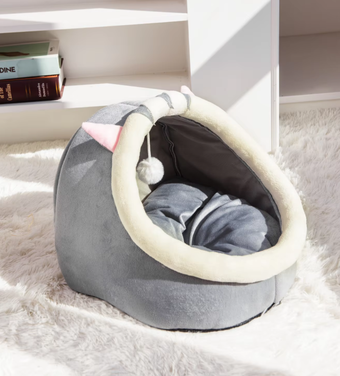 Cozy, washable igloo cat bed with a dangling toy ball, providing a soft cave for pet comfort.