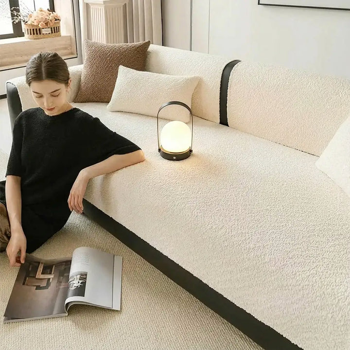 Lifestyle shot of a pet resting comfortably on a chenille sofa cover, illustrating its scratch protection
