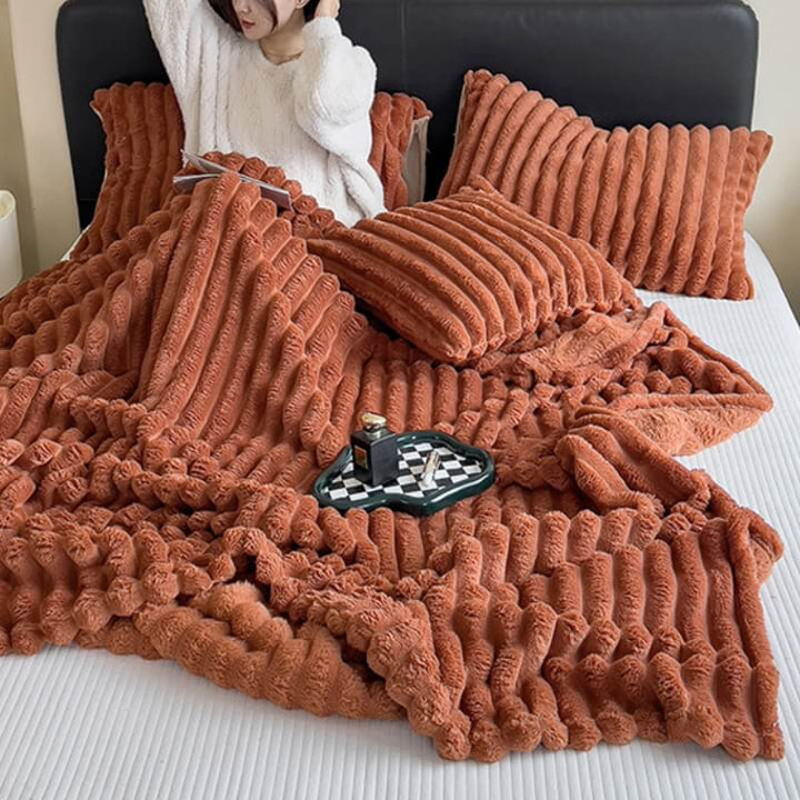 Luxurious faux rabbit fur throw blanket draped over a sofa, perfect for fall and winter comfort.