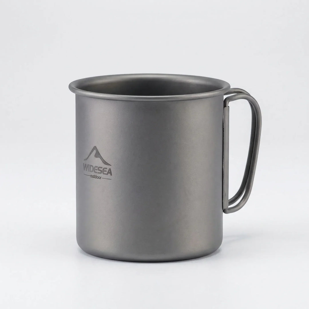 Unisex titanium mug with foldable handles, ready for a hot drink on a camping trip or hiking trail.