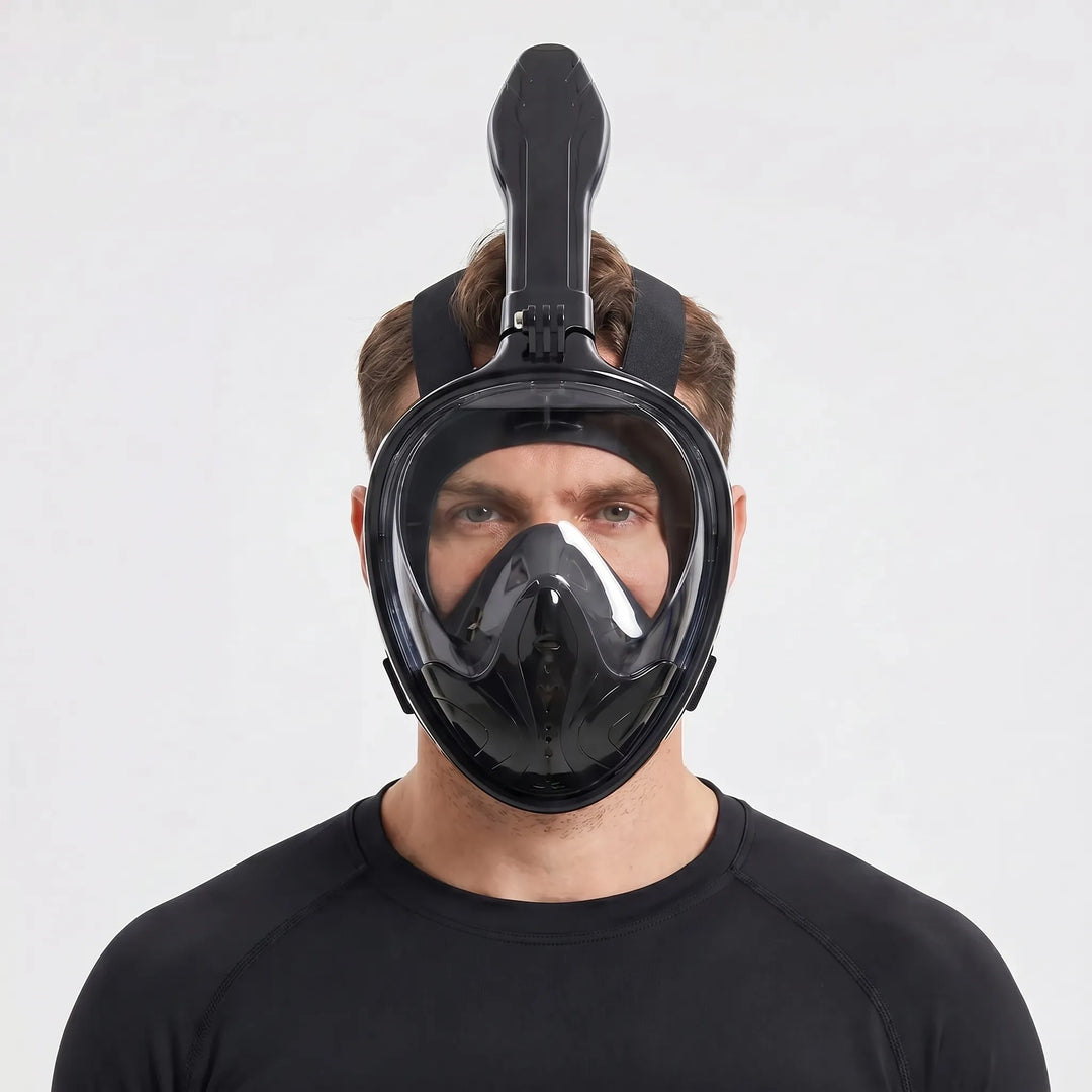 Person enjoying a panoramic underwater view with a black full-face snorkel mask on a tropical beach vacation.