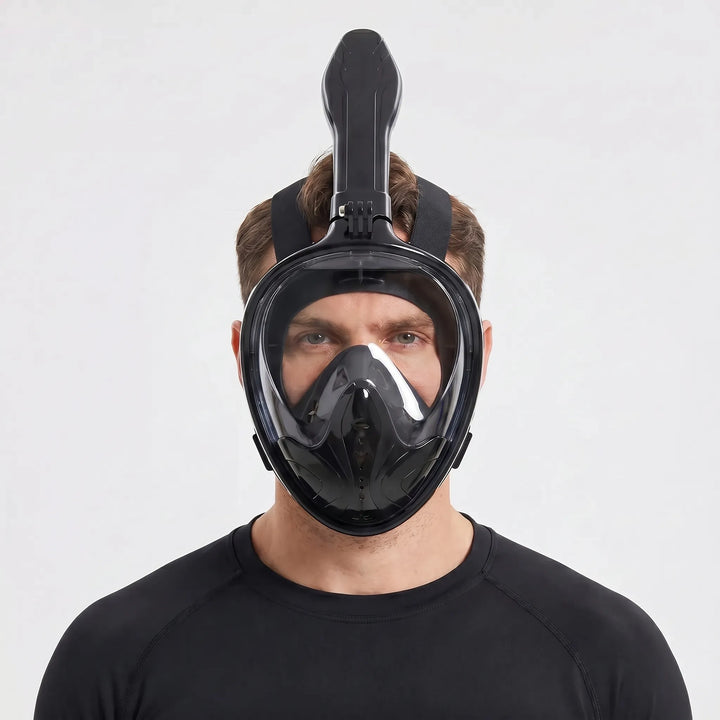 Person enjoying a panoramic underwater view with a black full-face snorkel mask on a tropical beach vacation.