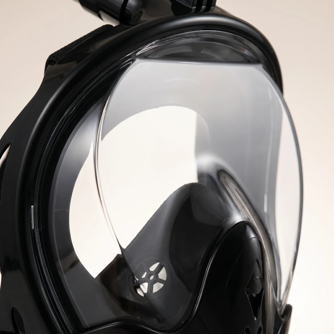 Clear anti-fog lens of a full-face snorkel mask, offering unobstructed panoramic views of marine life while swimming.