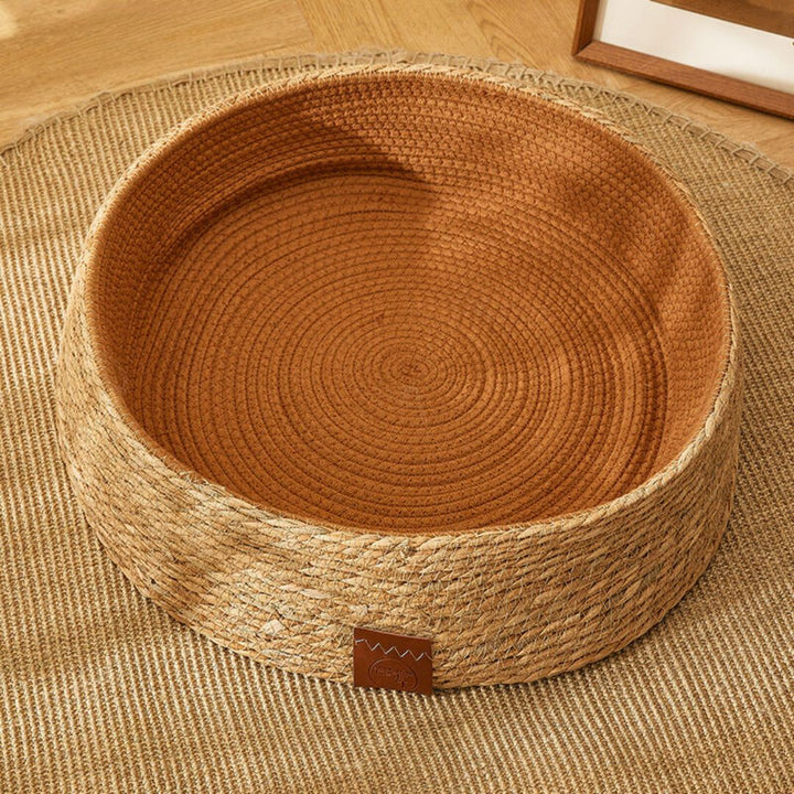 Durable handwoven rattan cat bed with removable cushion, a natural pet furniture solution