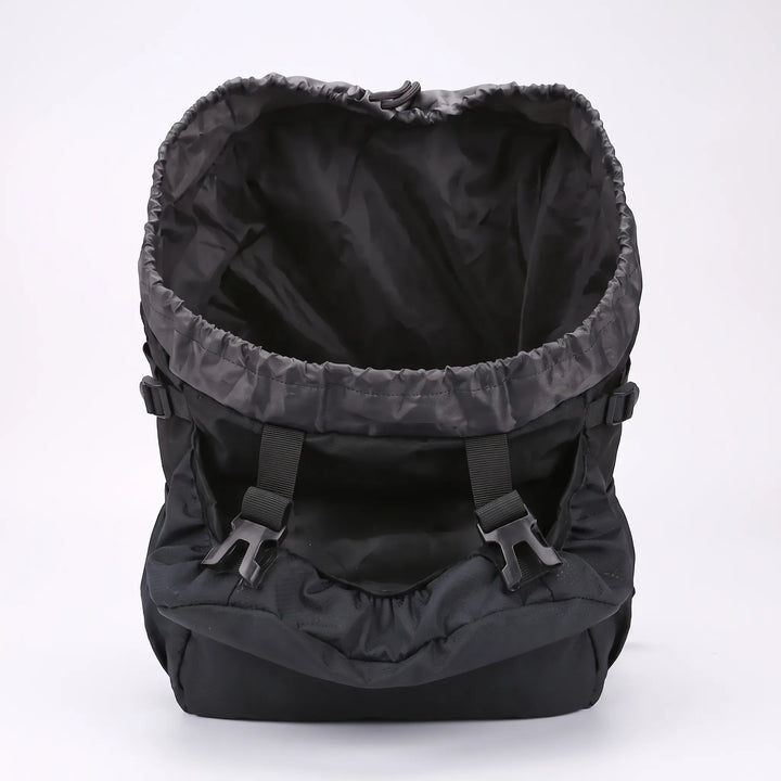 Adventurer wearing a unisex large capacity hiking backpack on a scenic mountain trail for camping.