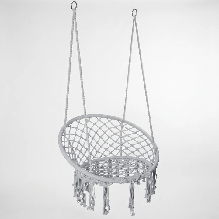 Close-up of the elegant macrame weave on a white hanging hammock swing chair, showcasing craftsmanship.