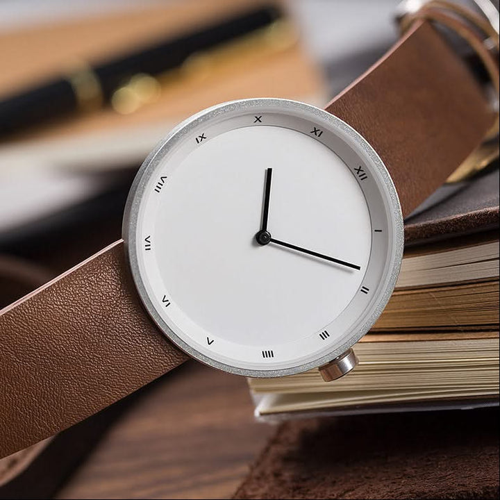 Elegant minimalist quartz wrist watch with a round black dial and classic black leather band.