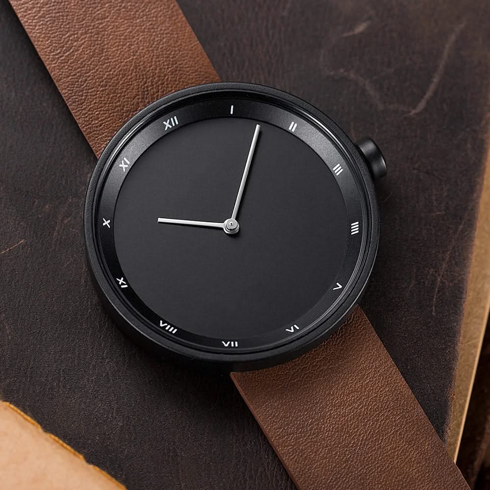 Classic unisex quartz wrist watch featuring a minimalist dial and a rich brown leather strap.