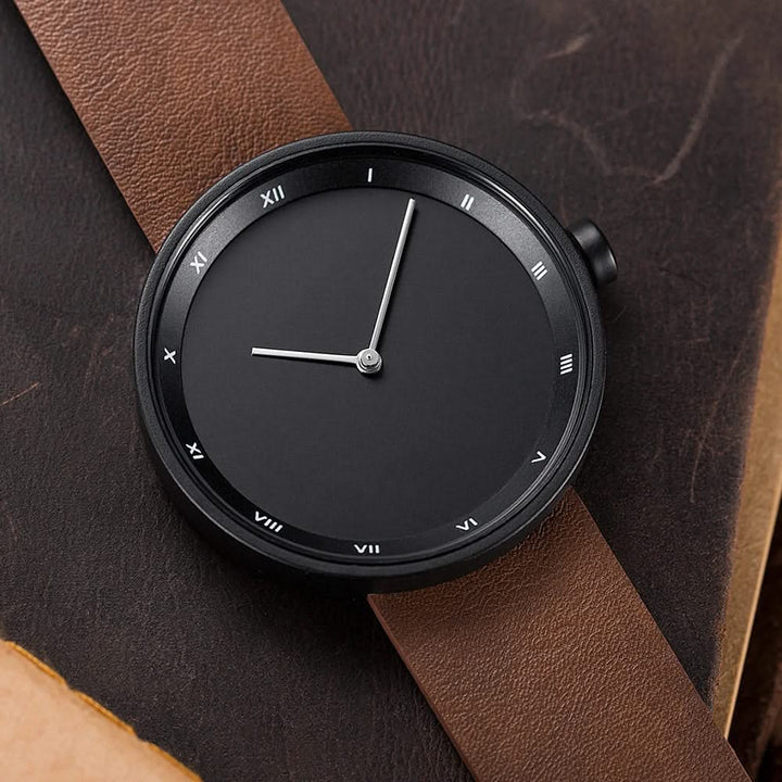 Classic unisex quartz wrist watch featuring a minimalist dial and a rich brown leather strap.