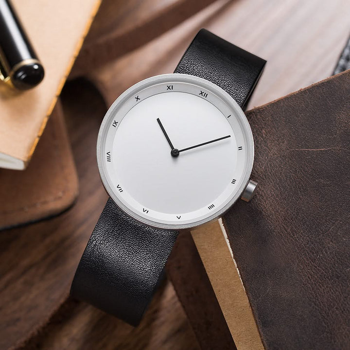 Close-up of a minimalist round face quartz wrist watch, highlighting its elegant and simple design.